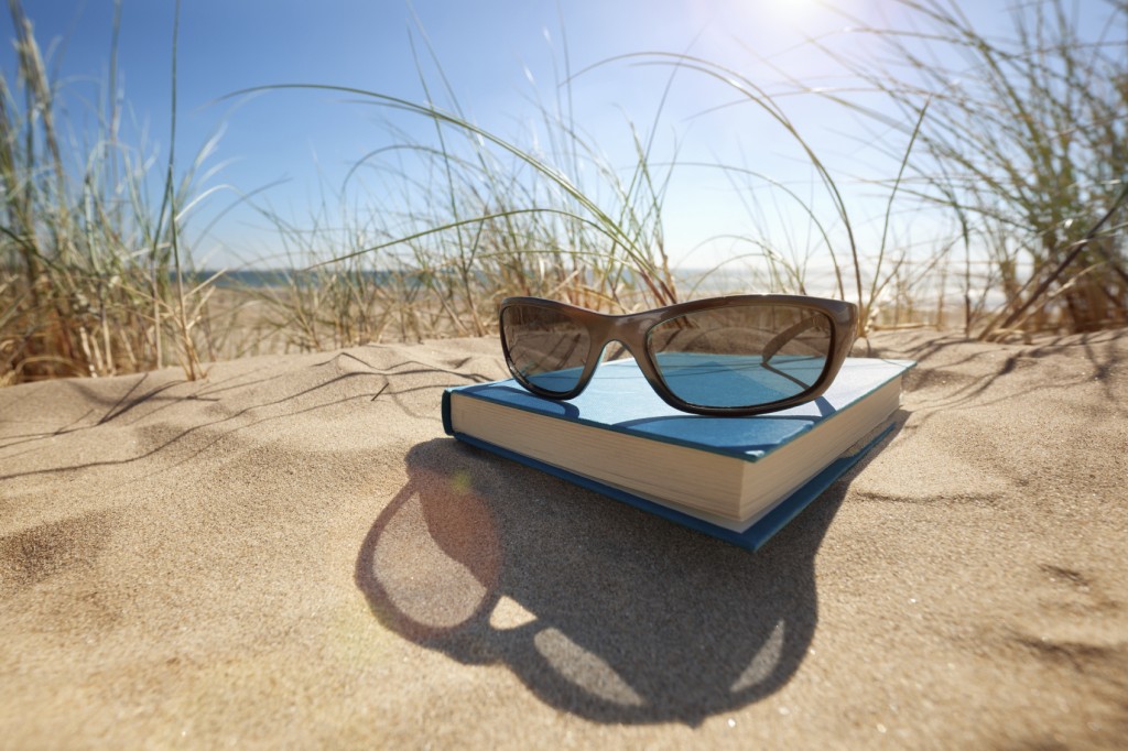 Book and sunglasses on the beach