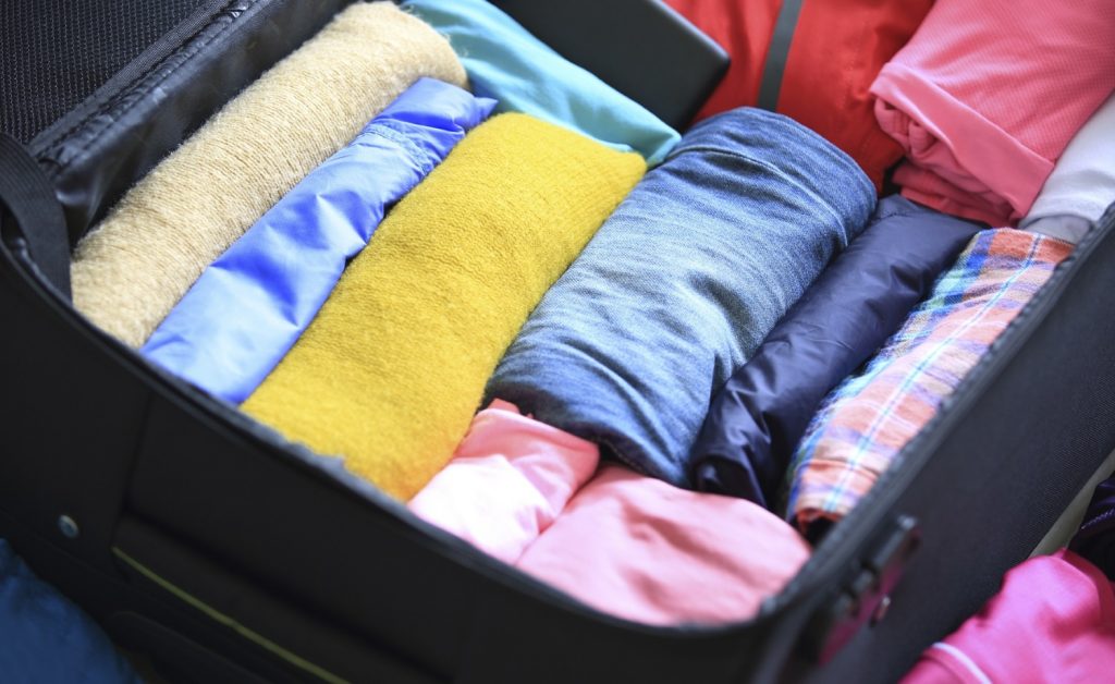 packed suitcase with rolled up clothes